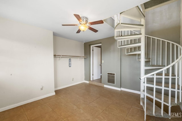 interior space featuring baseboards, heating unit, a ceiling fan, tile patterned flooring, and stairs