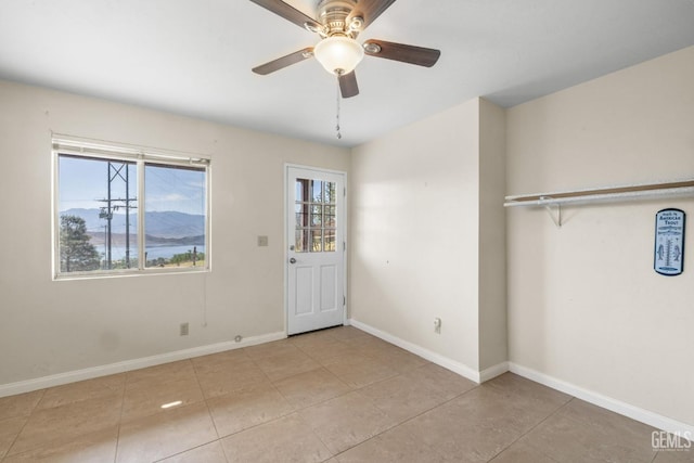unfurnished bedroom with a ceiling fan, baseboards, and light tile patterned floors