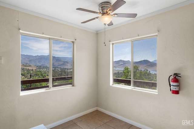 spare room with a mountain view, ceiling fan, and plenty of natural light