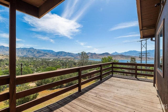 wooden terrace featuring a water and mountain view