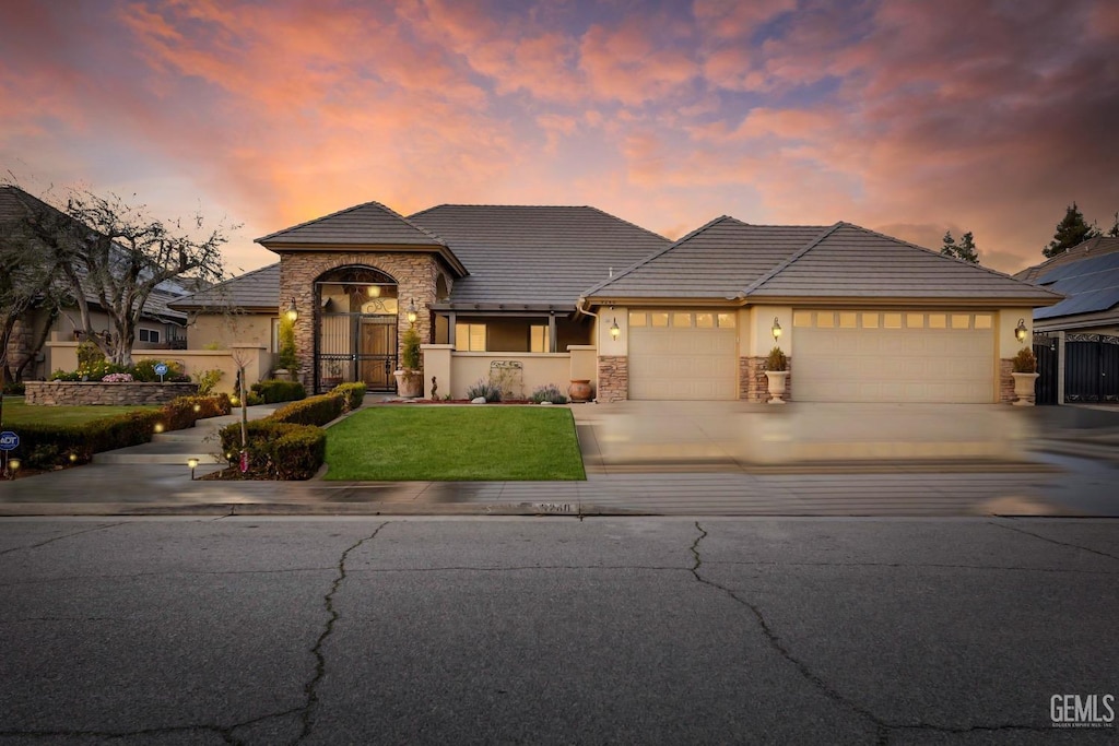 view of front of property with a garage and a lawn