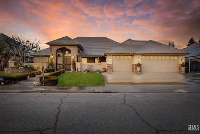 view of front of property with a garage and a lawn