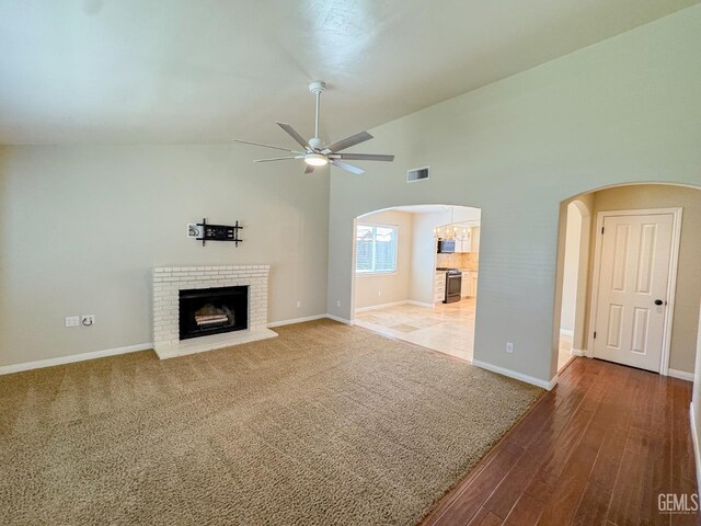 12301 Nacelle Ave, Bakersfield, CA 93312 - unfurnished living room with arched walkways, a fireplace, a ceiling fan, wood finished floors, and vaulted ceiling