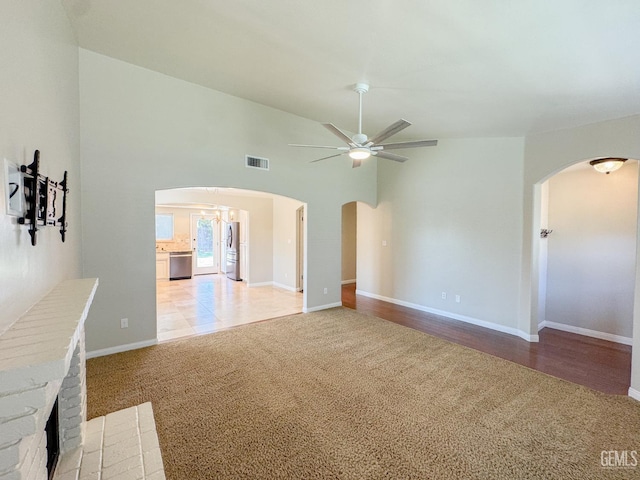 12301 Nacelle Ave, Bakersfield, CA 93312 - unfurnished living room with arched walkways, light carpet, a ceiling fan, and vaulted ceiling