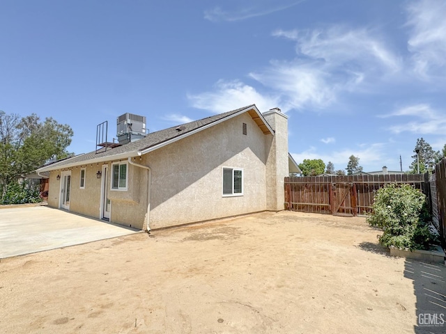 12301 Nacelle Ave, Bakersfield, CA 93312 - back of property with a fenced backyard, a chimney, a patio, and stucco siding