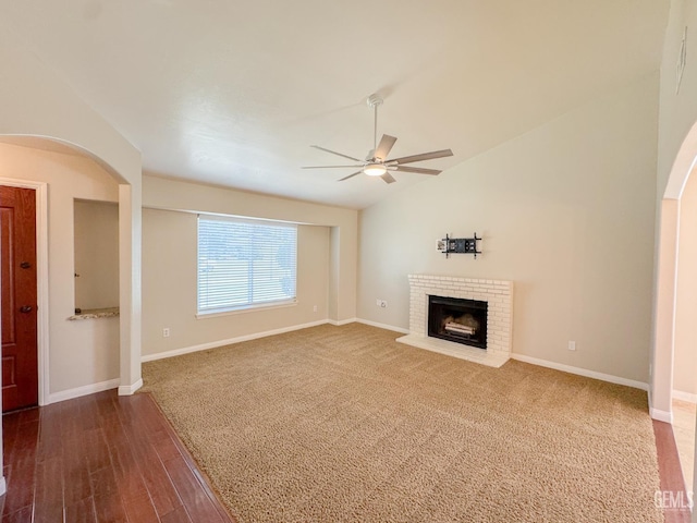 12301 Nacelle Ave, Bakersfield, CA 93312 - unfurnished living room featuring ceiling fan, a brick fireplace, arched walkways, dark wood-style floors, and vaulted ceiling