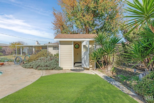 view of front of home featuring a front lawn, fence, and an outbuilding