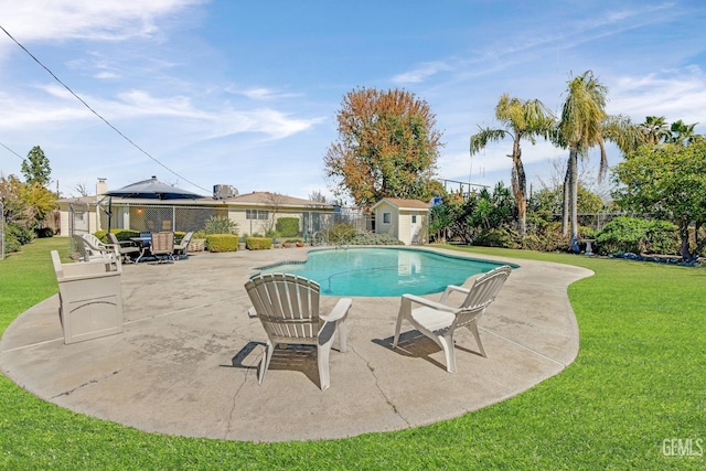 view of pool featuring a fenced in pool, a lawn, a patio area, a storage unit, and an outbuilding