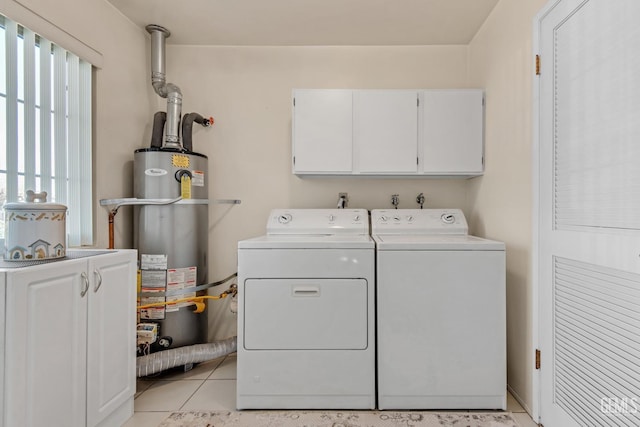 laundry area with water heater, cabinet space, light tile patterned flooring, and separate washer and dryer