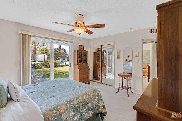 bedroom featuring a textured ceiling, visible vents, light colored carpet, and access to outside