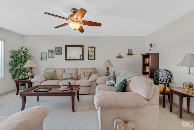 living area with light carpet, a textured ceiling, and a ceiling fan