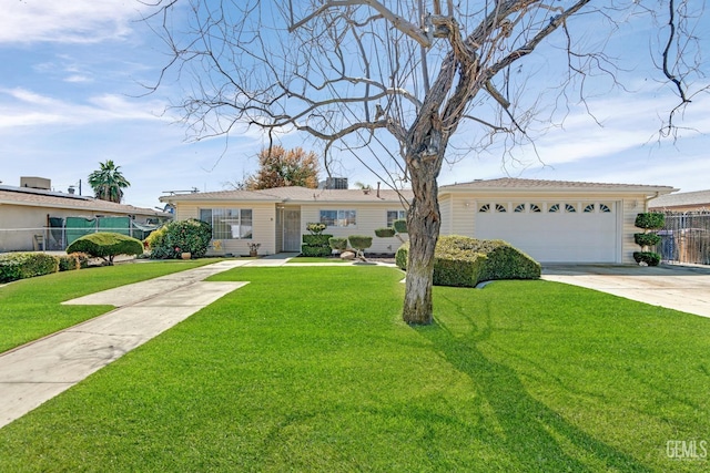 ranch-style house featuring a front yard, concrete driveway, fence, and a garage