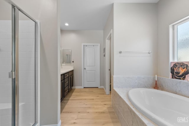 8610 Kowa St, Bakersfield, CA 93314 - full bathroom with vanity, a garden tub, a stall shower, wood finished floors, and recessed lighting