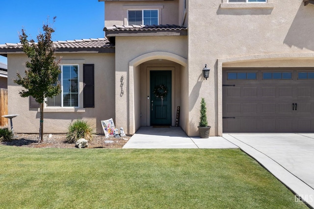 8610 Kowa St, Bakersfield, CA 93314 - property entrance featuring stucco siding, an attached garage, a lawn, driveway, and a tile roof