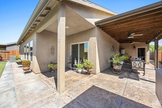 rear view of property with stucco siding, a patio, ceiling fan, and fence
