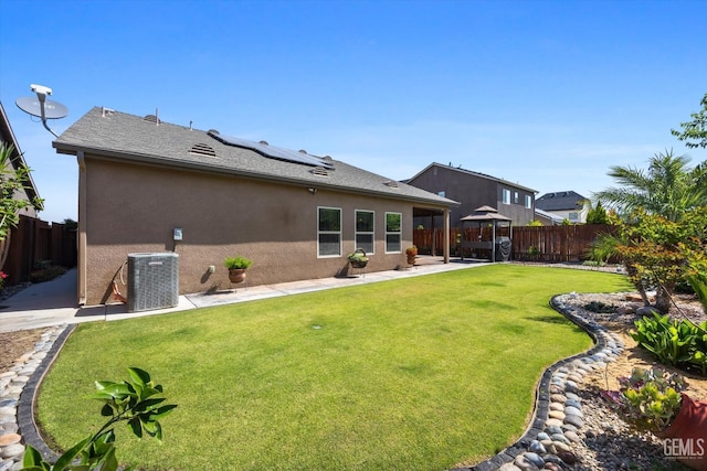 rear view of property featuring a gazebo, central AC unit, solar panels, stucco siding, and a patio area