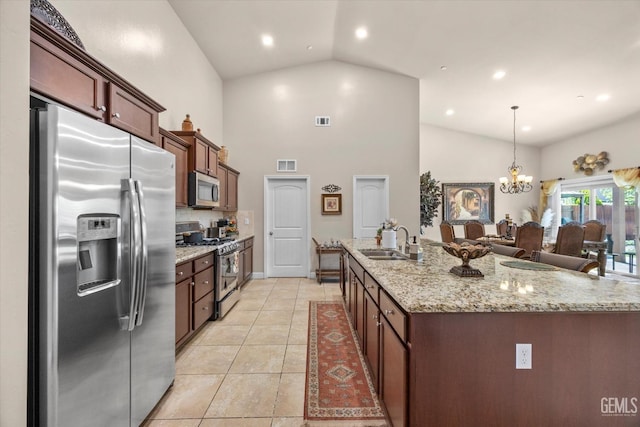 kitchen with appliances with stainless steel finishes, a sink, high vaulted ceiling, a chandelier, and light stone countertops