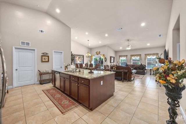 kitchen featuring dishwasher, light tile patterned floors, a sink, a ceiling fan, and a kitchen island with sink