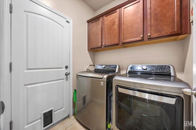 washroom with washer and clothes dryer, cabinet space, and light tile patterned floors