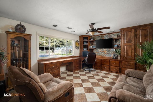 office featuring built in study area, ceiling fan, visible vents, and light floors