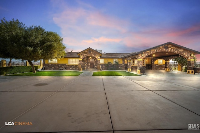 view of front of house with stone siding and a yard