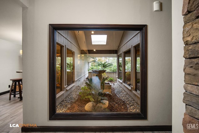 interior space featuring wood-type flooring and a skylight