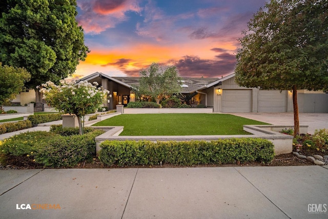 view of front of home with a yard and a garage