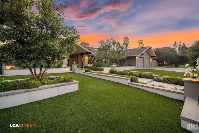 view of front facade featuring driveway, an attached garage, and a front yard