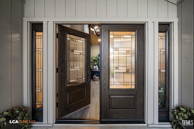 entrance foyer with wood-type flooring, an inviting chandelier, lofted ceiling, and wood ceiling