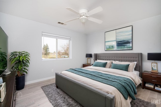 bedroom featuring light wood-type flooring, visible vents, ceiling fan, and baseboards