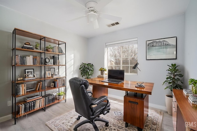 office space featuring visible vents, ceiling fan, light wood-style flooring, and baseboards