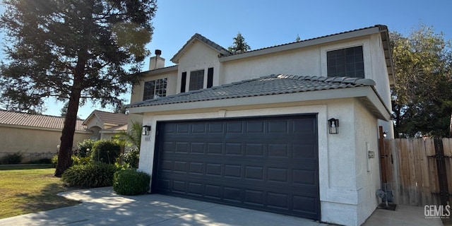 8808 Cape Flattery Dr, Bakersfield, CA 93312 - traditional-style home with stucco siding, a chimney, driveway, a tile roof, and a garage