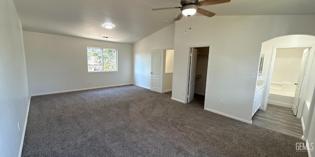 8808 Cape Flattery Dr, Bakersfield, CA 93312 - unfurnished bedroom with arched walkways, dark colored carpet, a walk in closet, vaulted ceiling, and ensuite bath