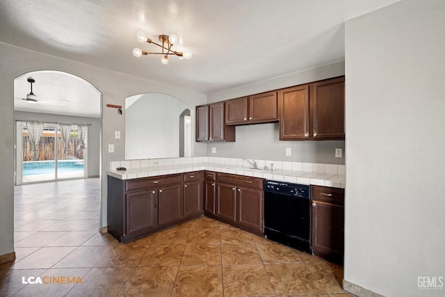 3400 Tori Lorene Ave, Bakersfield, CA 93313 - kitchen with tile countertops, black dishwasher, arched walkways, a chandelier, and light tile patterned floors