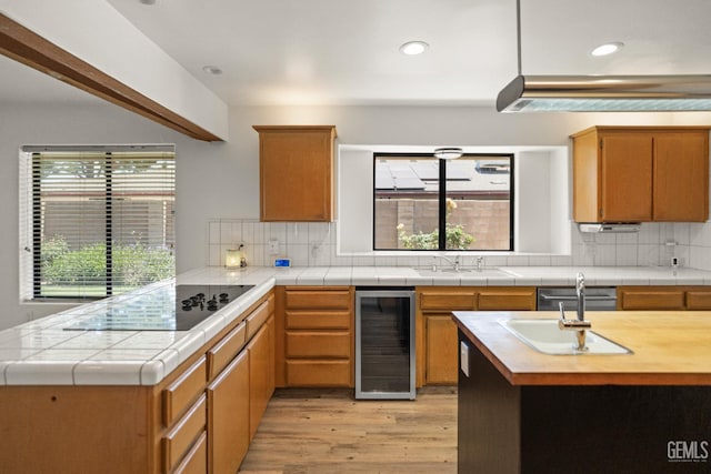7108 Luke Ave, Bakersfield, CA 93308 - kitchen with wine cooler, black electric stovetop, light wood-style flooring, plenty of natural light, and recessed lighting
