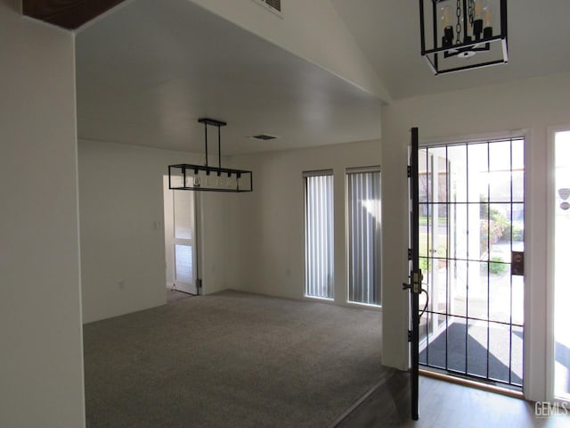 interior space with carpet floors and vaulted ceiling