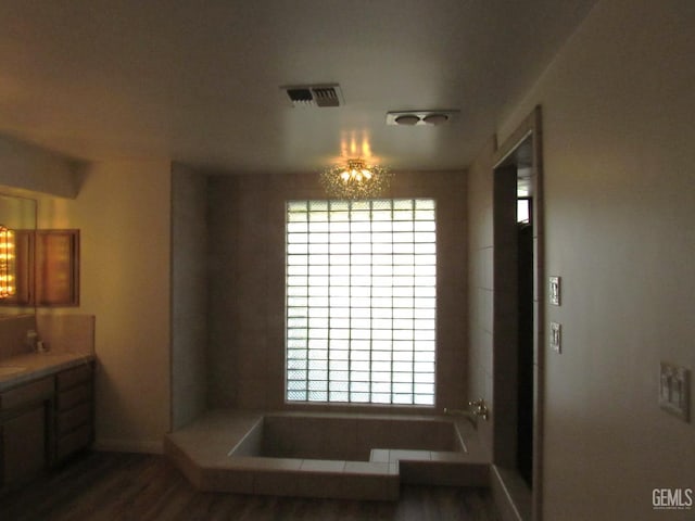 bathroom with hardwood / wood-style floors, vanity, and a washtub