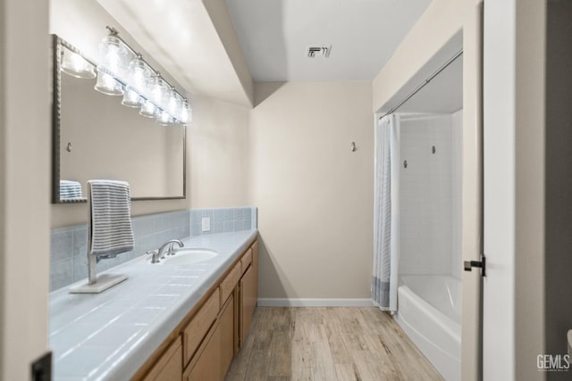 7108 Luke Ave, Bakersfield, CA 93308 - bathroom with vanity, wood finished floors, shower / bathtub combination with curtain, and tasteful backsplash