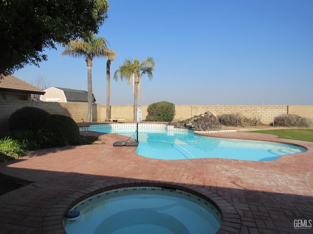 view of pool featuring a patio and an in ground hot tub