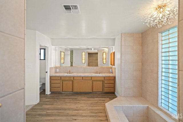 7108 Luke Ave, Bakersfield, CA 93308 - bathroom featuring double vanity, wood finished floors, toilet, and a chandelier