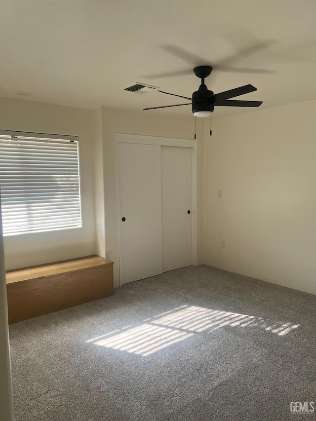 unfurnished bedroom with carpet floors, a closet, and ceiling fan