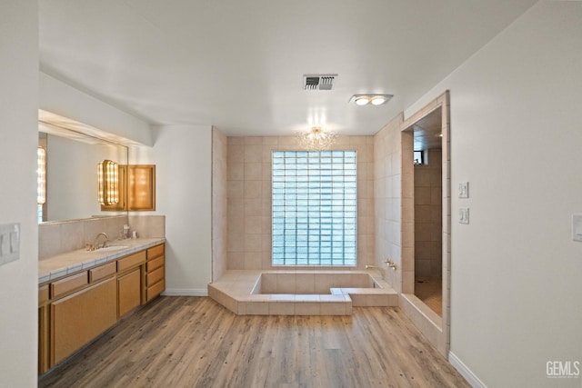 7108 Luke Ave, Bakersfield, CA 93308 - full bath with vanity, wood finished floors, baseboards, and tiled shower
