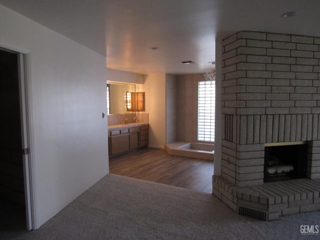 interior space featuring hardwood / wood-style flooring, sink, and a brick fireplace