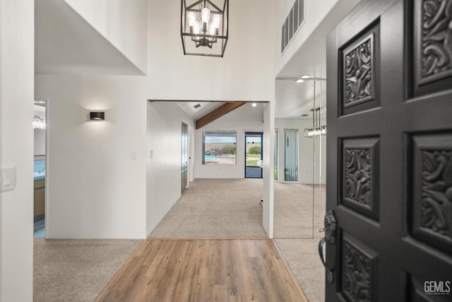 7108 Luke Ave, Bakersfield, CA 93308 - foyer with a chandelier, carpet flooring, wood finished floors, and a high ceiling