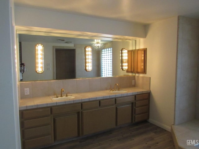 bathroom with vanity, backsplash, and hardwood / wood-style flooring