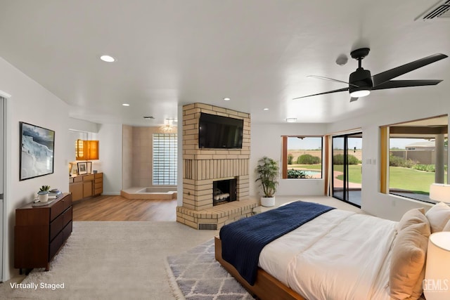 7108 Luke Ave, Bakersfield, CA 93308 - bedroom featuring access to exterior, recessed lighting, a brick fireplace, light wood-type flooring, and baseboards