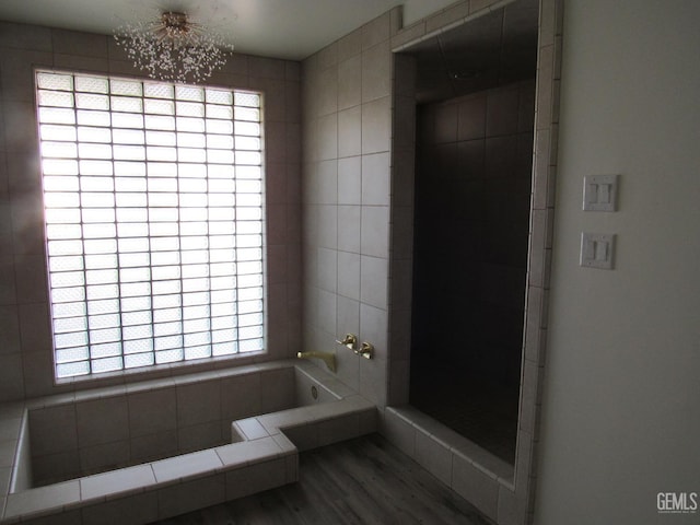 bathroom with a healthy amount of sunlight, wood-type flooring, and a washtub