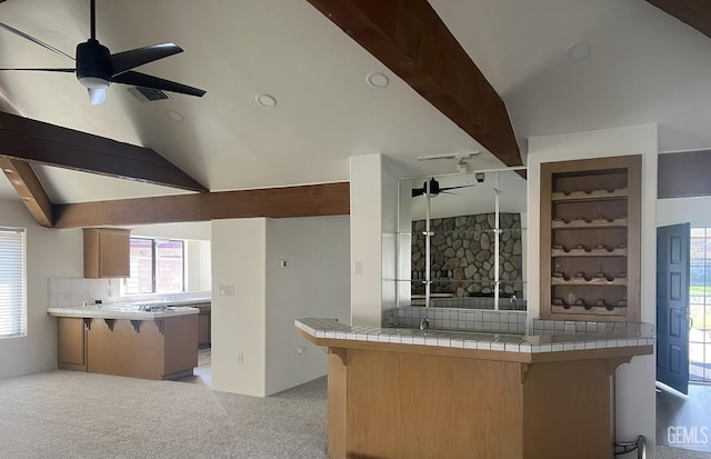 kitchen featuring built in shelves, tile counters, ceiling fan, and kitchen peninsula