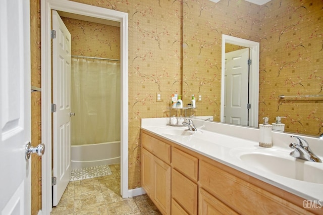 bathroom featuring double vanity, stone finish floor, shower / bath combo, and a sink