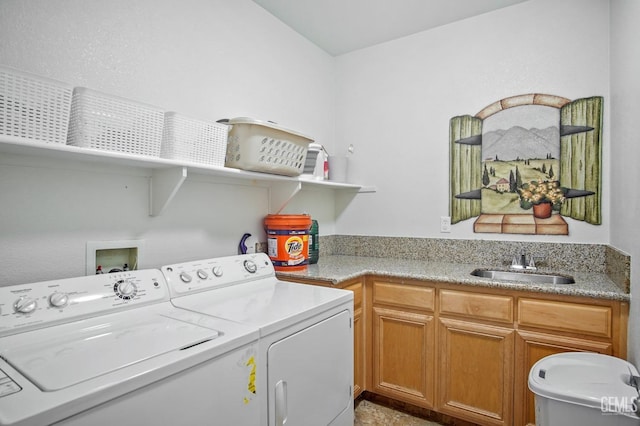 laundry room with washer and dryer, cabinet space, and a sink